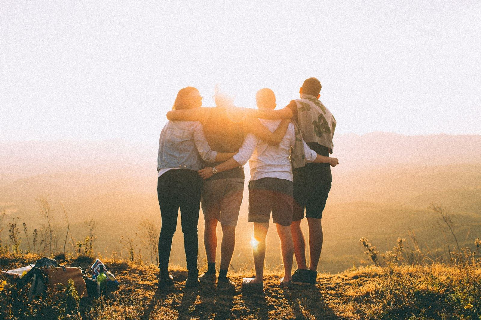 Grupo de amigos abrazados al atardecer